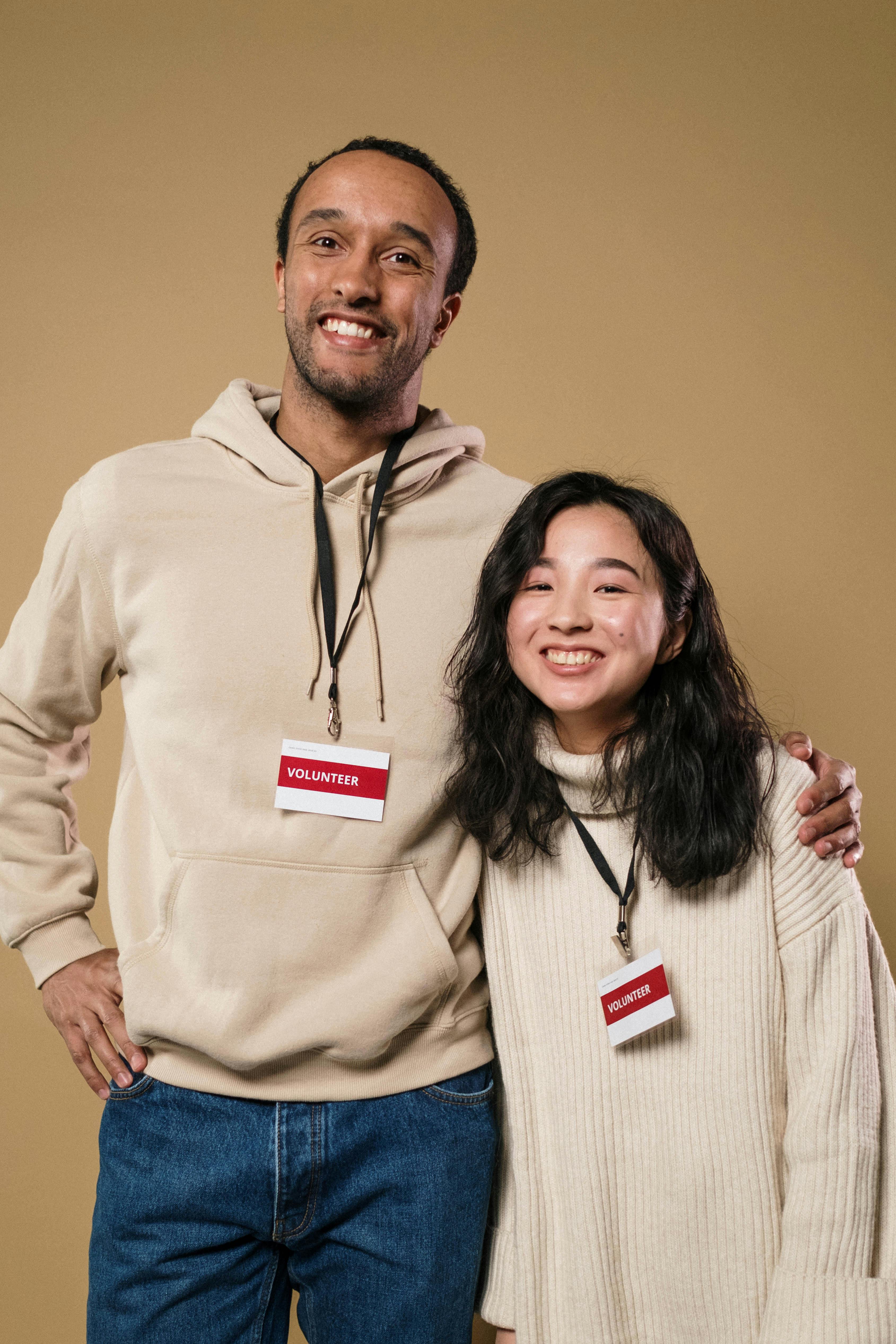 Two smiling volunteers wearing name badges